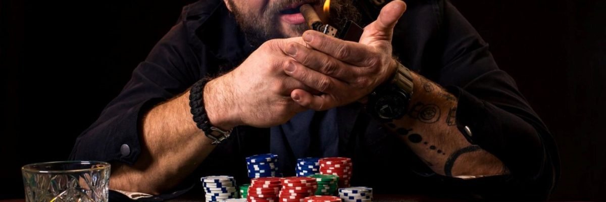 A man smoking a cigar over a stack of chips.