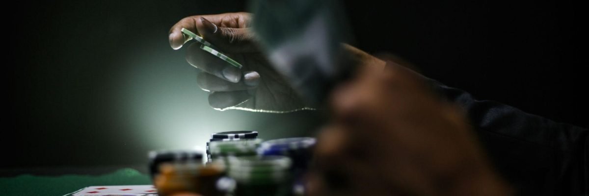A poker chip is held in a person's hand, highlighting the importance of finding ways to stop gambling.