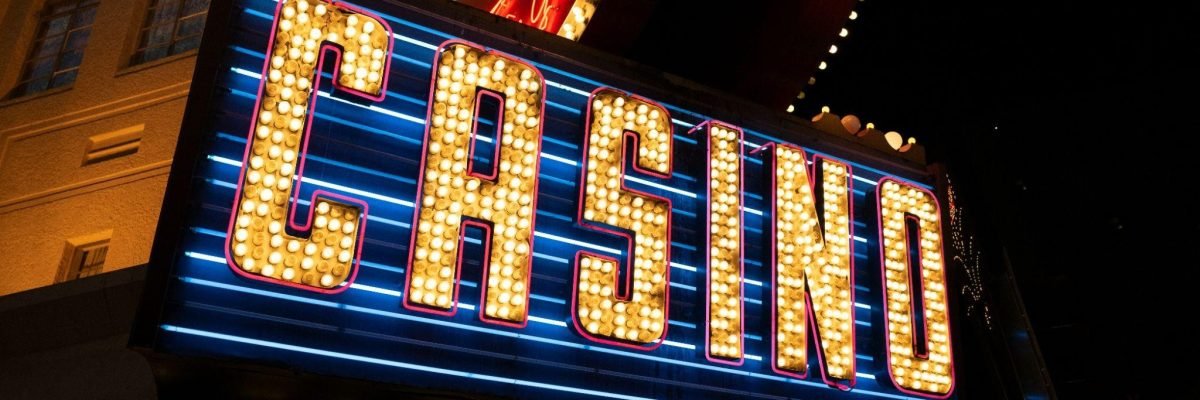 Illuminated casino sign at night, depicting the hidden dangers of casinos.